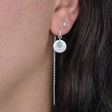 A Galaxy Opal Thread Earring, featuring a mint green gem, worn by a person with dark hair.