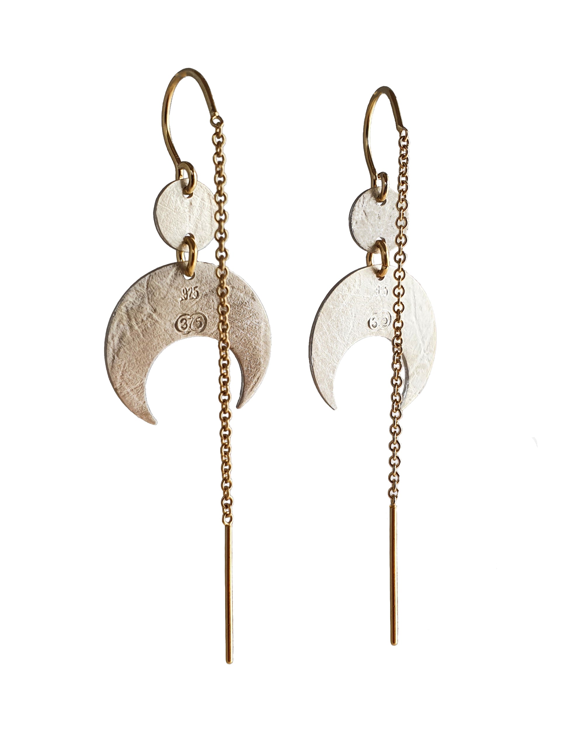 Pair of silver crescent moon earrings with gold chains on a white background