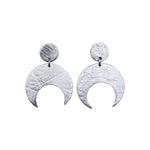 Pair of Sterling Silver Lunar stud earrings on a white background. These earrings feature a textured crescent moon design.