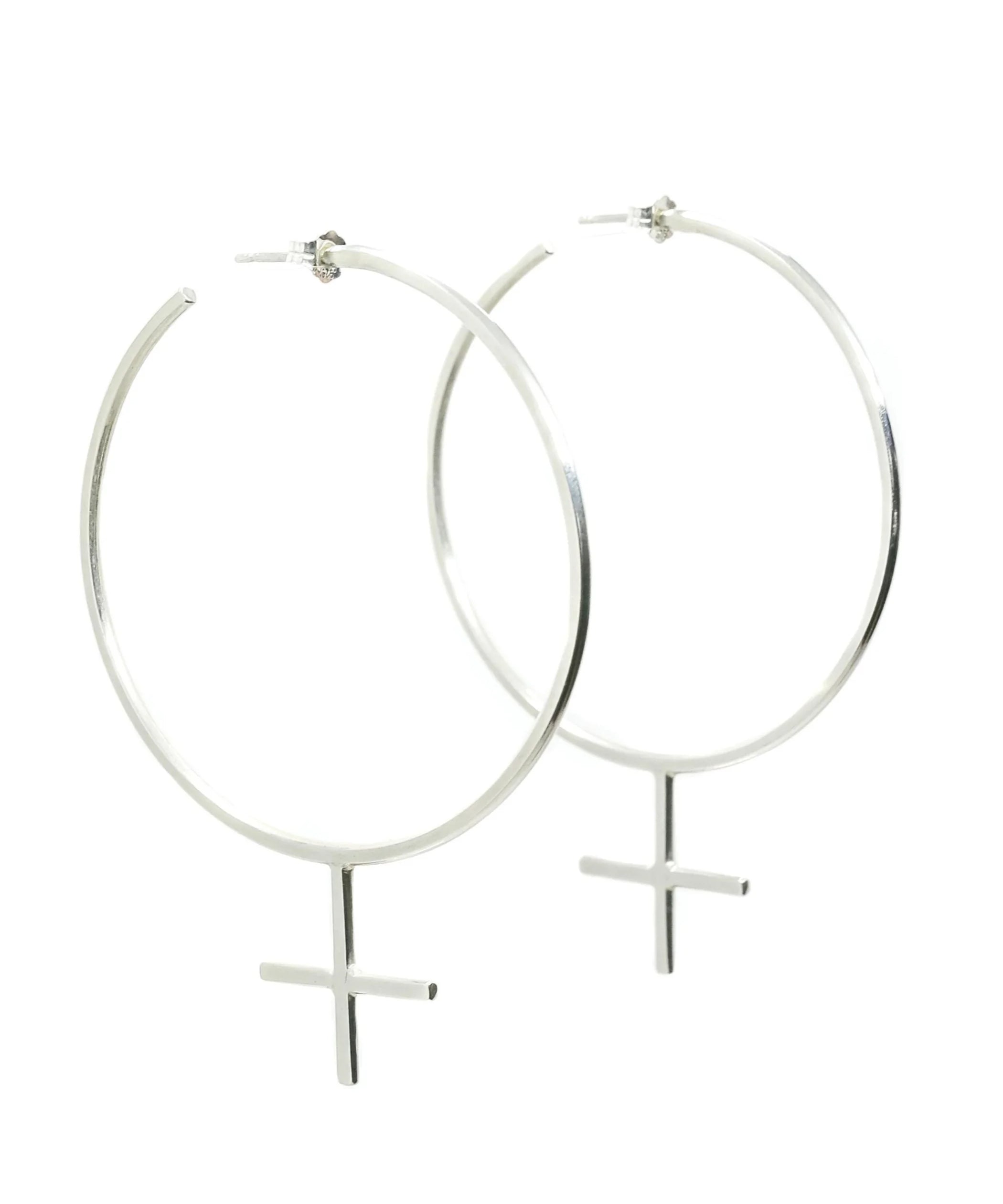 The Venus Hoop Sterling Silver Earrings, handmade by Emily Eliza Arlotte in Hobart, Tasmania sit on a white background. The oversized hoops are in the shape of the feminist femme symbol.