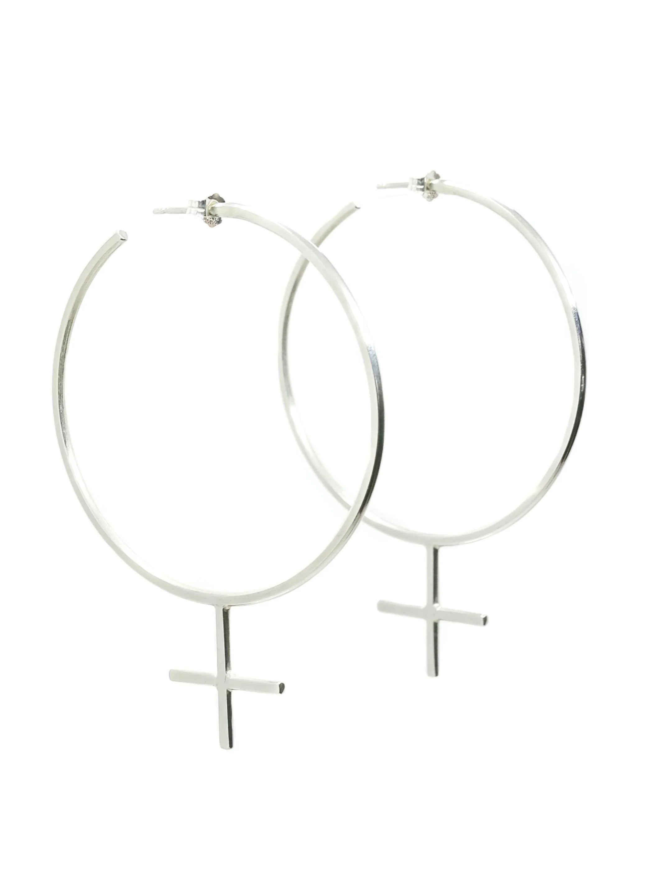 The Venus Hoop Sterling Silver Earrings, handmade by Emily Eliza Arlotte in Hobart, Tasmania sit on a white background. The oversized hoops are in the shape of the feminist femme symbol.