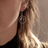 Close-up of a person wearing the Sterling Silver Divination Quartz Sphere Threader Earrings with a blurred background.