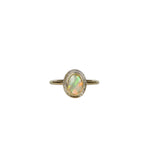 Close-up of Aura Gold Oval Crystal Opal Ring displayed on a white background, showcasing the opal's unique transparency, ethereal quality, and the kaleidoscope of colours reflecting from the gold setting