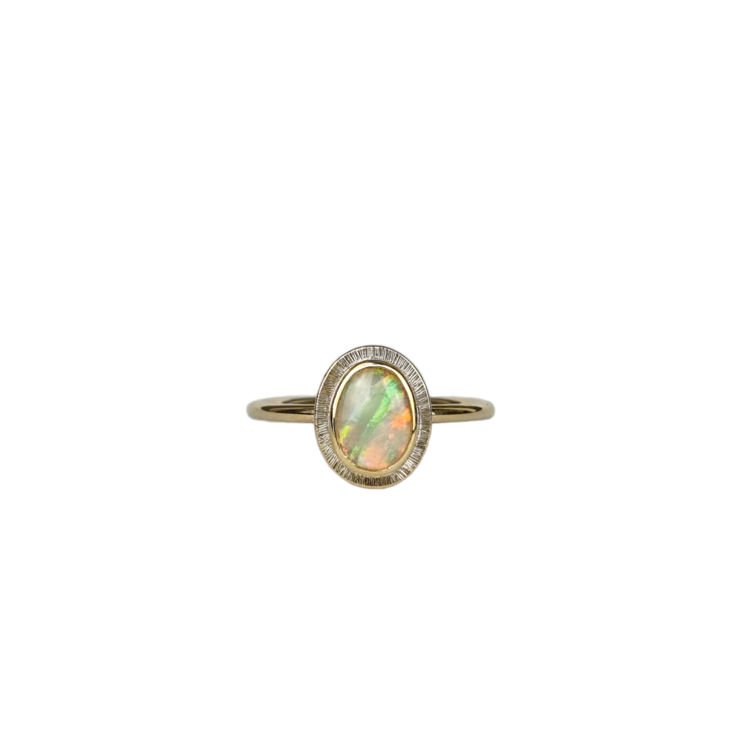 Close-up of Aura Gold Oval Crystal Opal Ring displayed on a white background, showcasing the opal's unique transparency, ethereal quality, and the kaleidoscope of colours reflecting from the gold setting