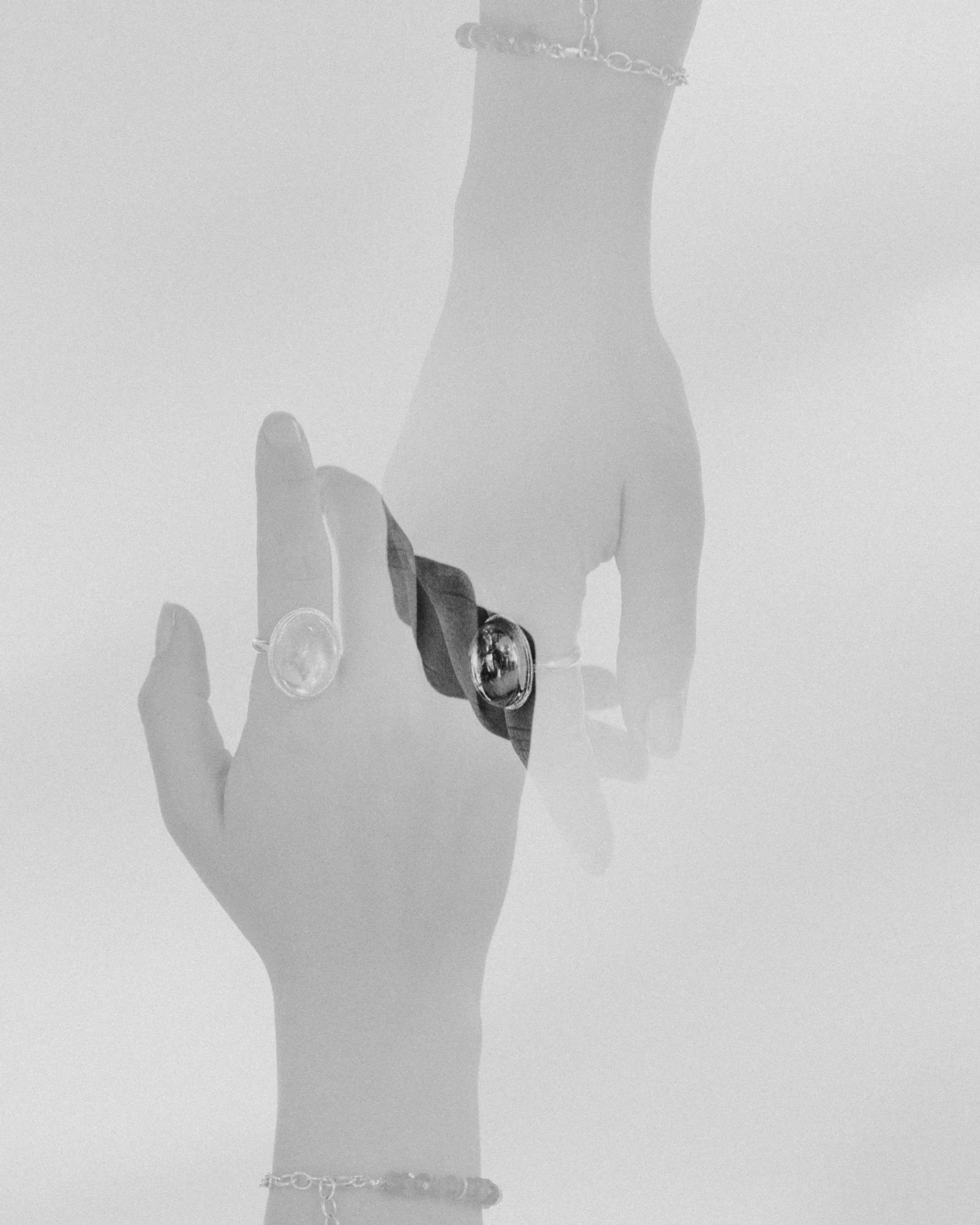 Black and white double exposure photograph of a hand wearing a quartz Prescience Ring by Emily Eliza Arlotte. Photo by Cassie Sullivan.