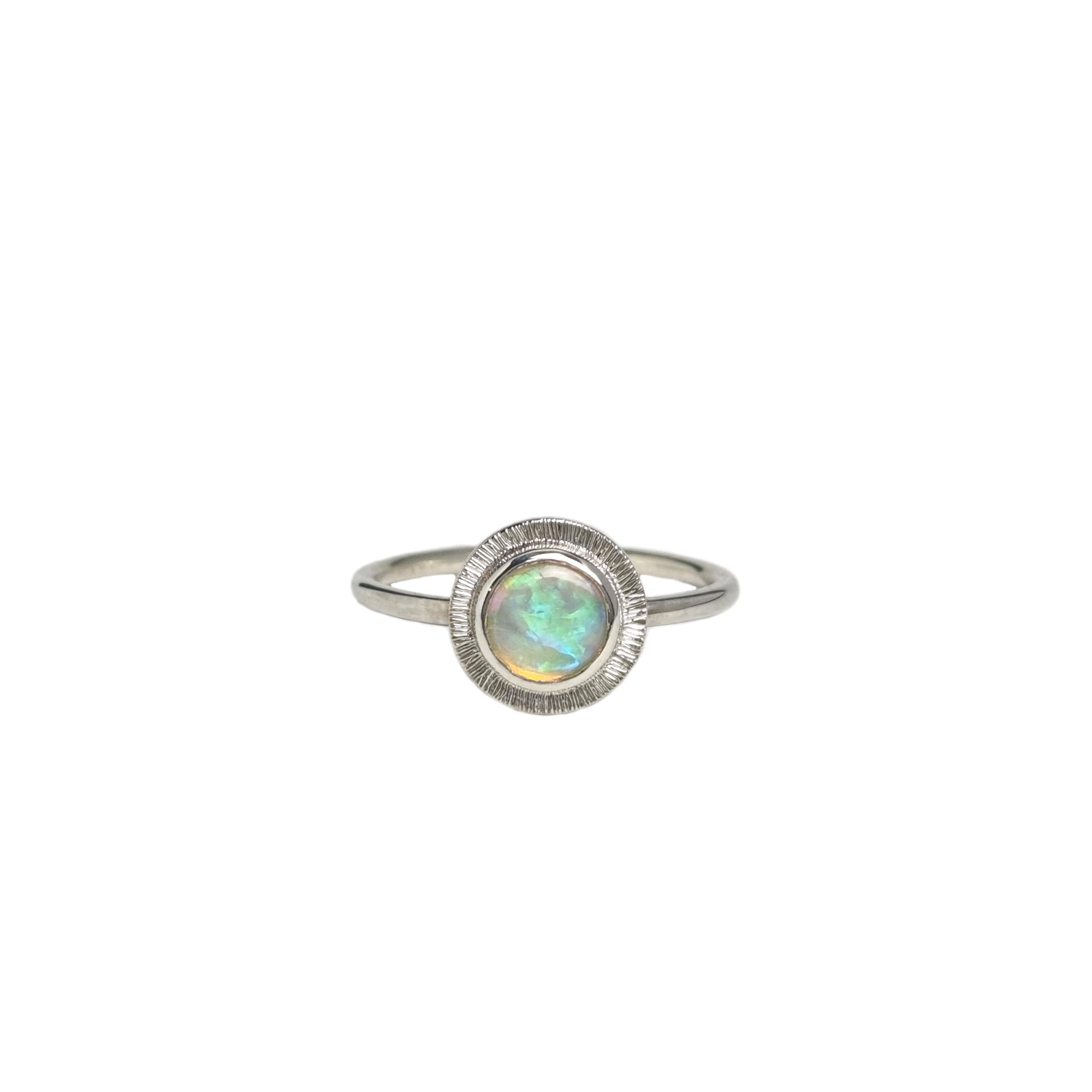A handmade sterling silver ring featuring an Australian Crystal Opal from Coober Pedy. The opal features pinks, greens, and blue swirls of colour and is set in a radiant engraved silver setting.