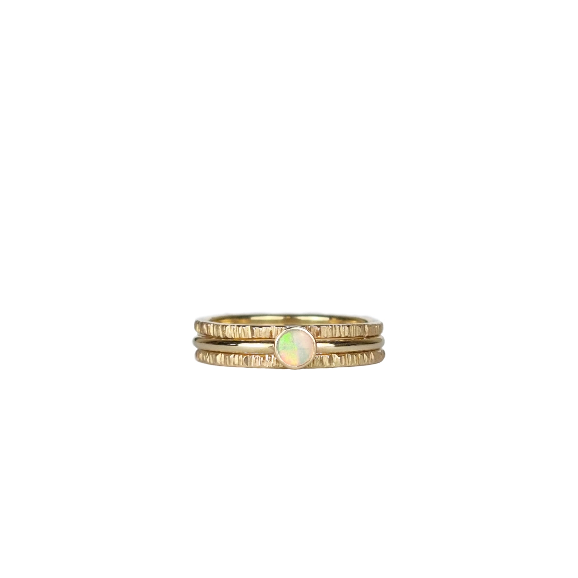 Three-piece Crystal Opal Gold Stack Ring Set displayed on a white background, highlighting the unique transparency and kaleidoscope of colours of the Australian Crystal Opal