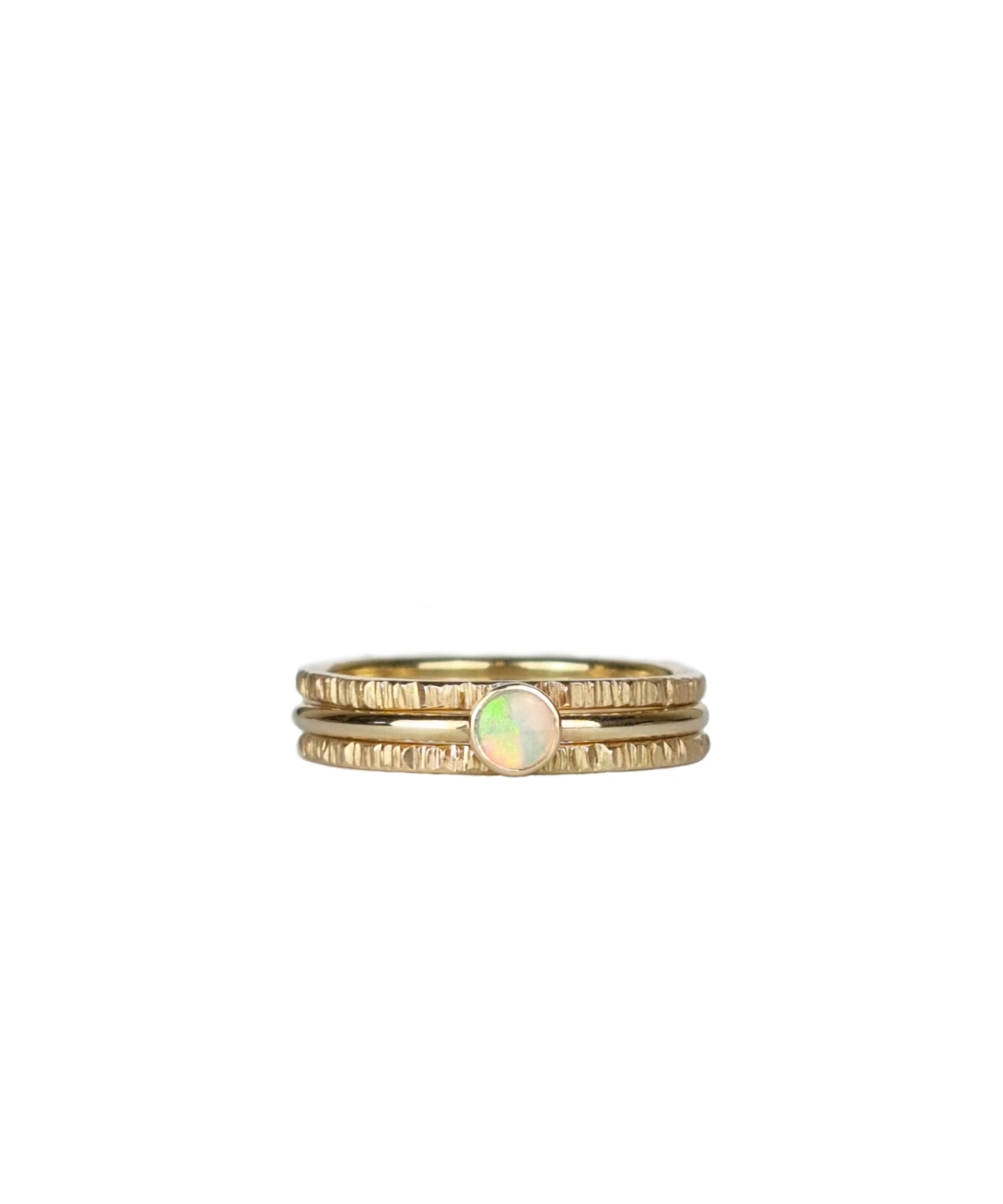 Three-piece Crystal Opal Gold Stack Ring Set displayed on a white background, highlighting the unique transparency and kaleidoscope of colours of the Australian Crystal Opal