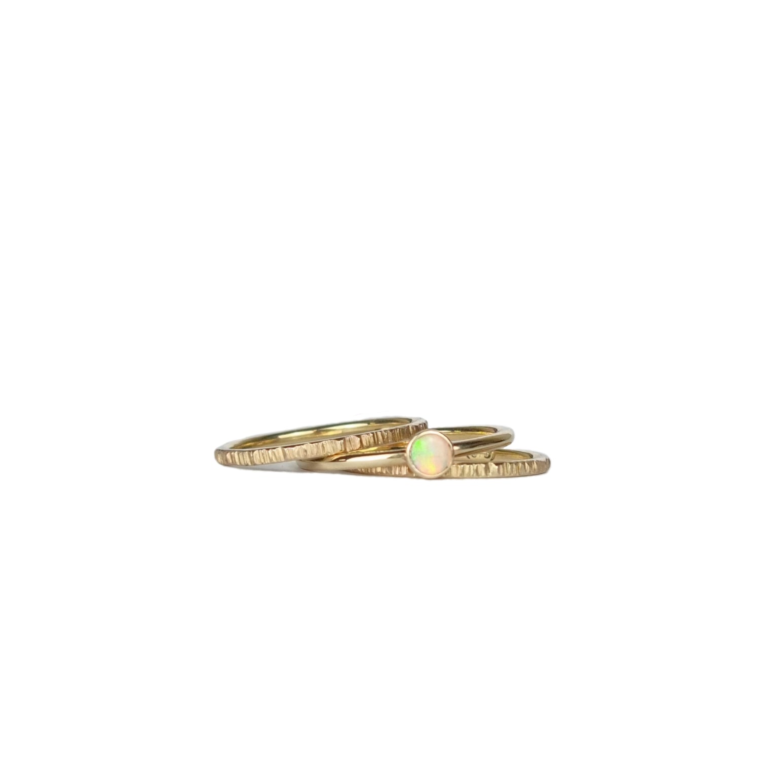 Crystal Opal Gold Stack Ring Set on a white background, featuring three 1.5mm stack rings—two with a textured finish and one with a vibrant Australian Crystal Opal.