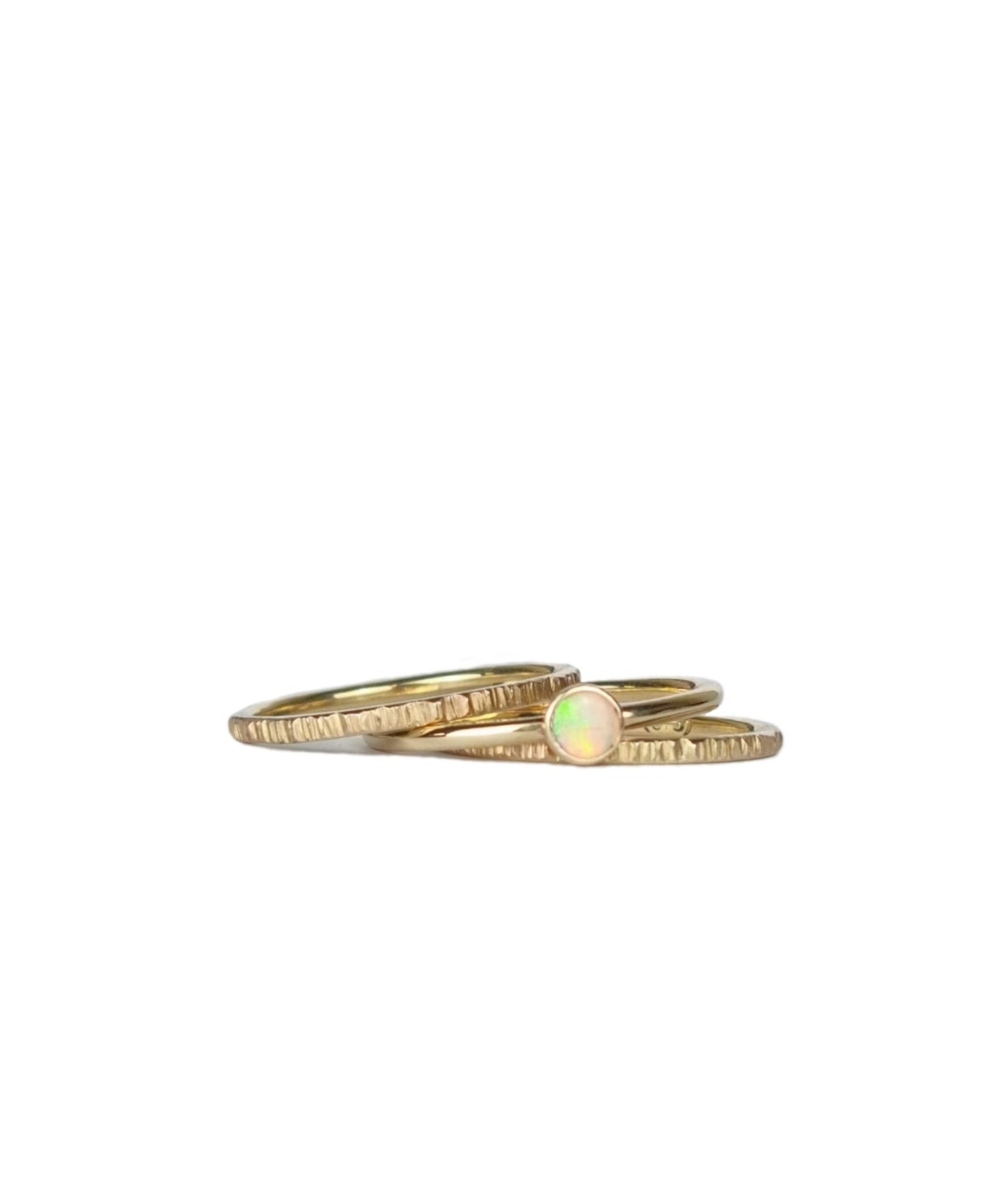 Crystal Opal Gold Stack Ring Set on a white background, featuring three 1.5mm stack rings—two with a textured finish and one with a vibrant Australian Crystal Opal.