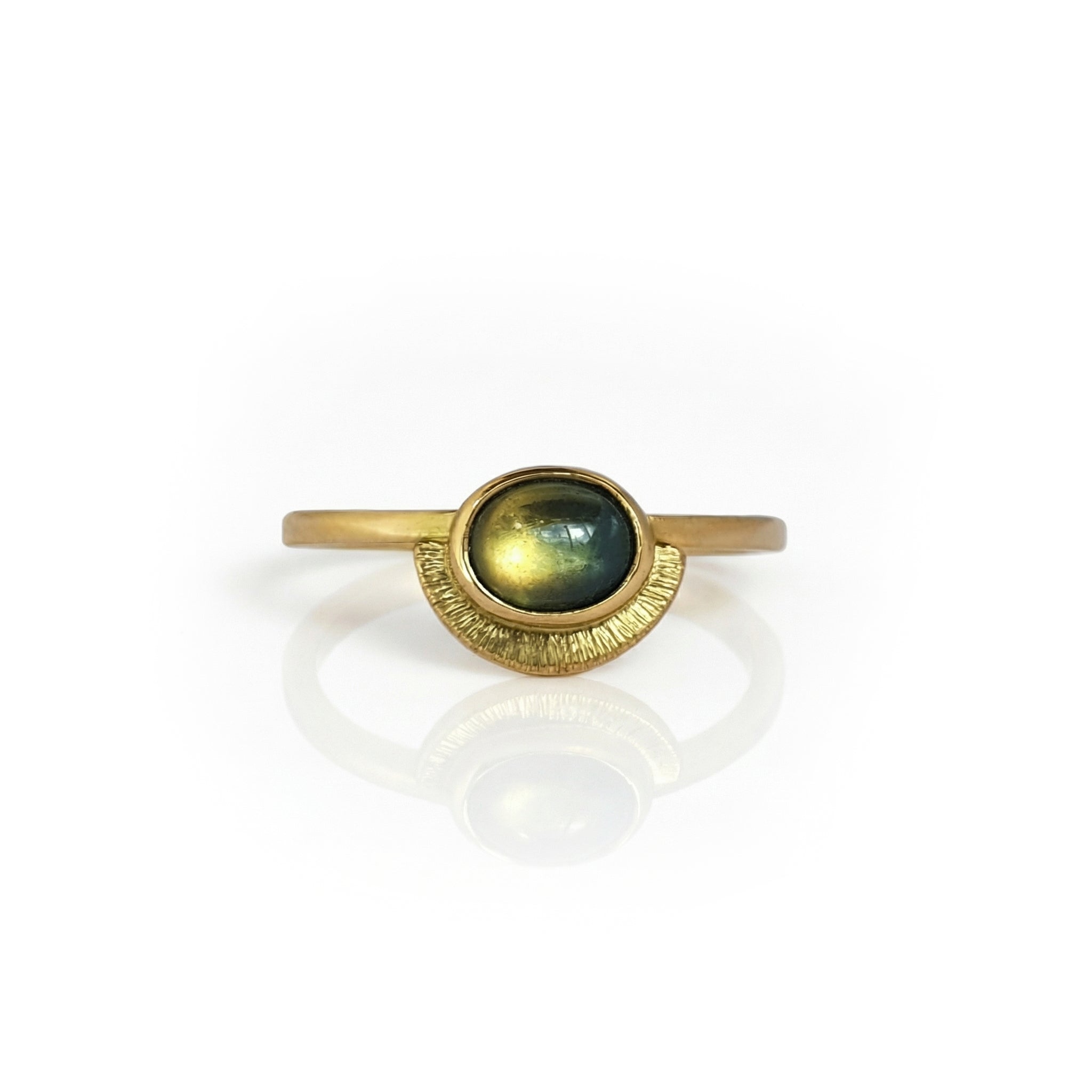 Handcrafted 18ct yellow gold engagement ring featuring an oval Australian sapphire cabochon, set in a bezel with a textured half-moon detail beneath the stone.