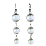 A pair of sterling silver drop earrings featuring three quartz spheres attached to small silver hooks.