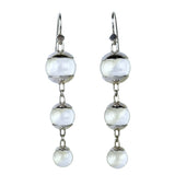A pair of sterling silver drop earrings featuring three quartz spheres attached to small silver hooks.