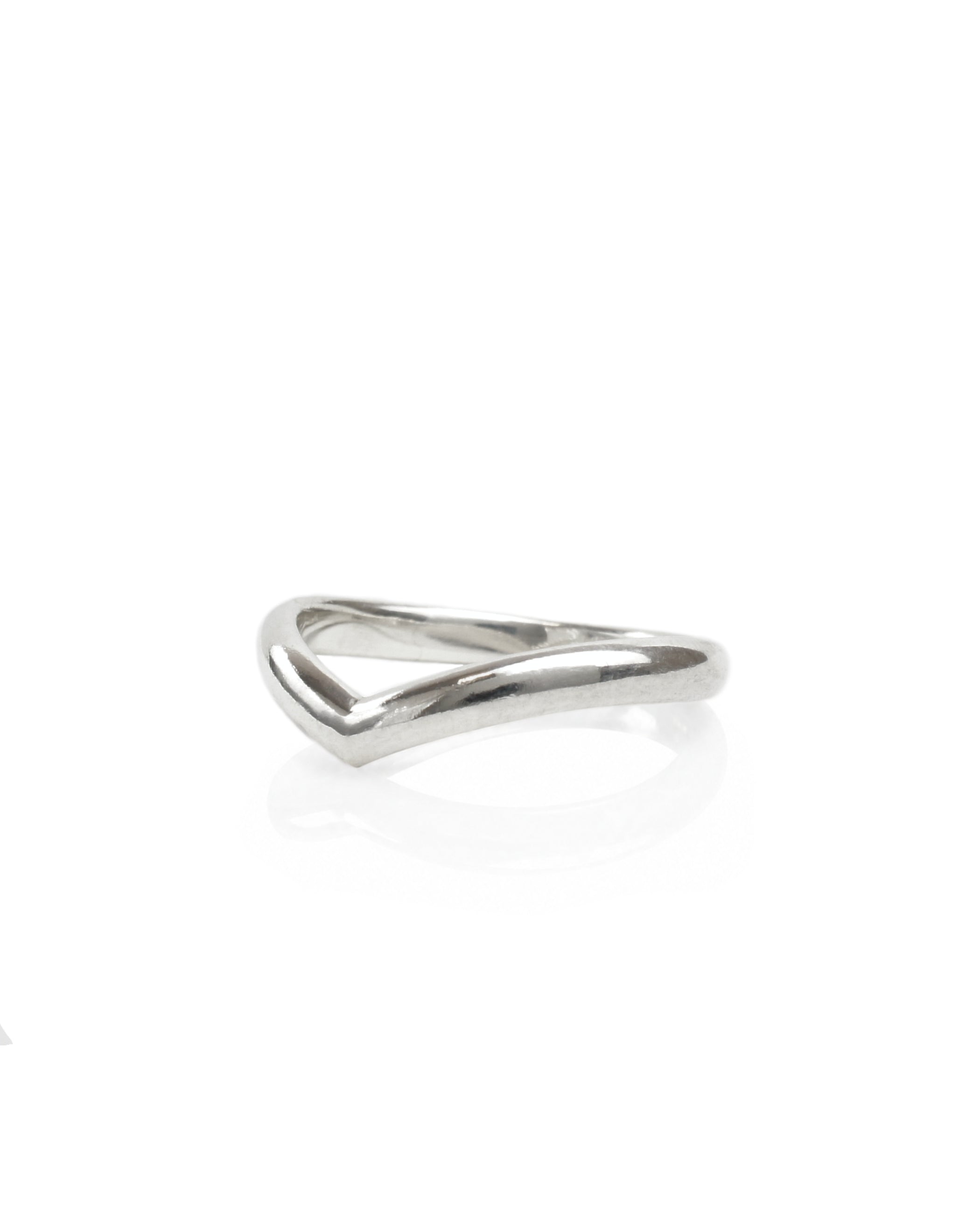 A side view of a Sterling Silver Wishbone Wedding Ring, sitting on a white reflective surface. Handmade by Emily Eliza Arlotte in Hobart, Tasmania.