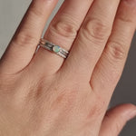 Close-up video of a hand wearing the Crystal Opal Silver Stack Ring Set in sunlight, highlighting the opal's unique transparency and kaleidoscope of colours against the textured Silver bands.