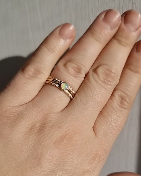 Crystal Opal Gold Stack Ring Set worn in bright sunlight, capturing the shifting colours of the Australian Crystal Opal and the intricate texture of the 9ct gold rings.