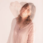 Editorial Photo shoot by Cassie Sullivan Photography of a model in soft pinkl Double Exposure movement image wearing Sterling Silver Venus Symbol Large Oversized Feminist Hoop Earrings 