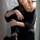  Model Eden is shown sitting in a window seal  wearing the faceted Pyrite and Gold beaded choker necklace with oxidised sterling silver chain. Handmade by Emily Eliza Arlotte in Hobart, Tasmania. Photography by Cassie Sullivan