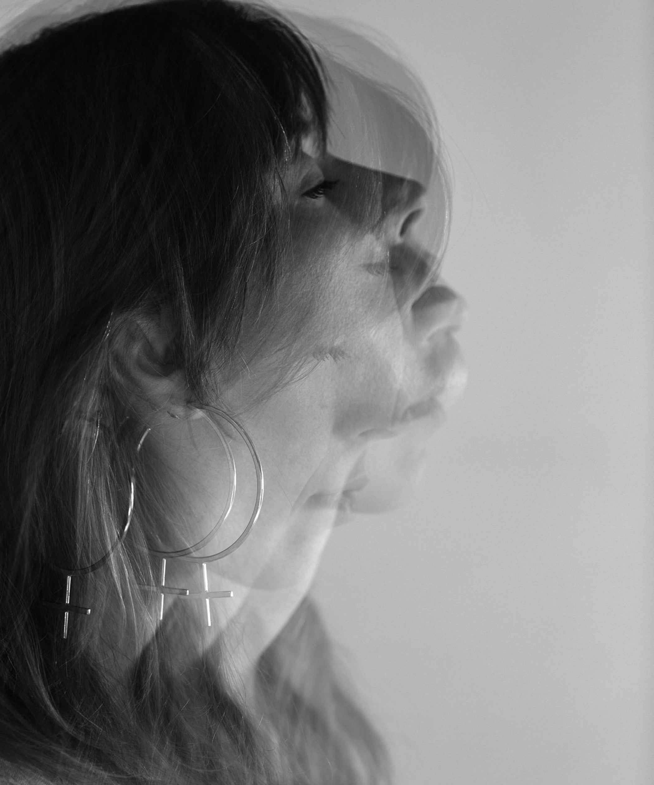 Editorial Photo shoot by Cassie Sullivan Photography of a model in black and white Double Exposure movement image wearing Sterling Silver Venus Symbol Large Oversized Feminist Hoop Earrings 
