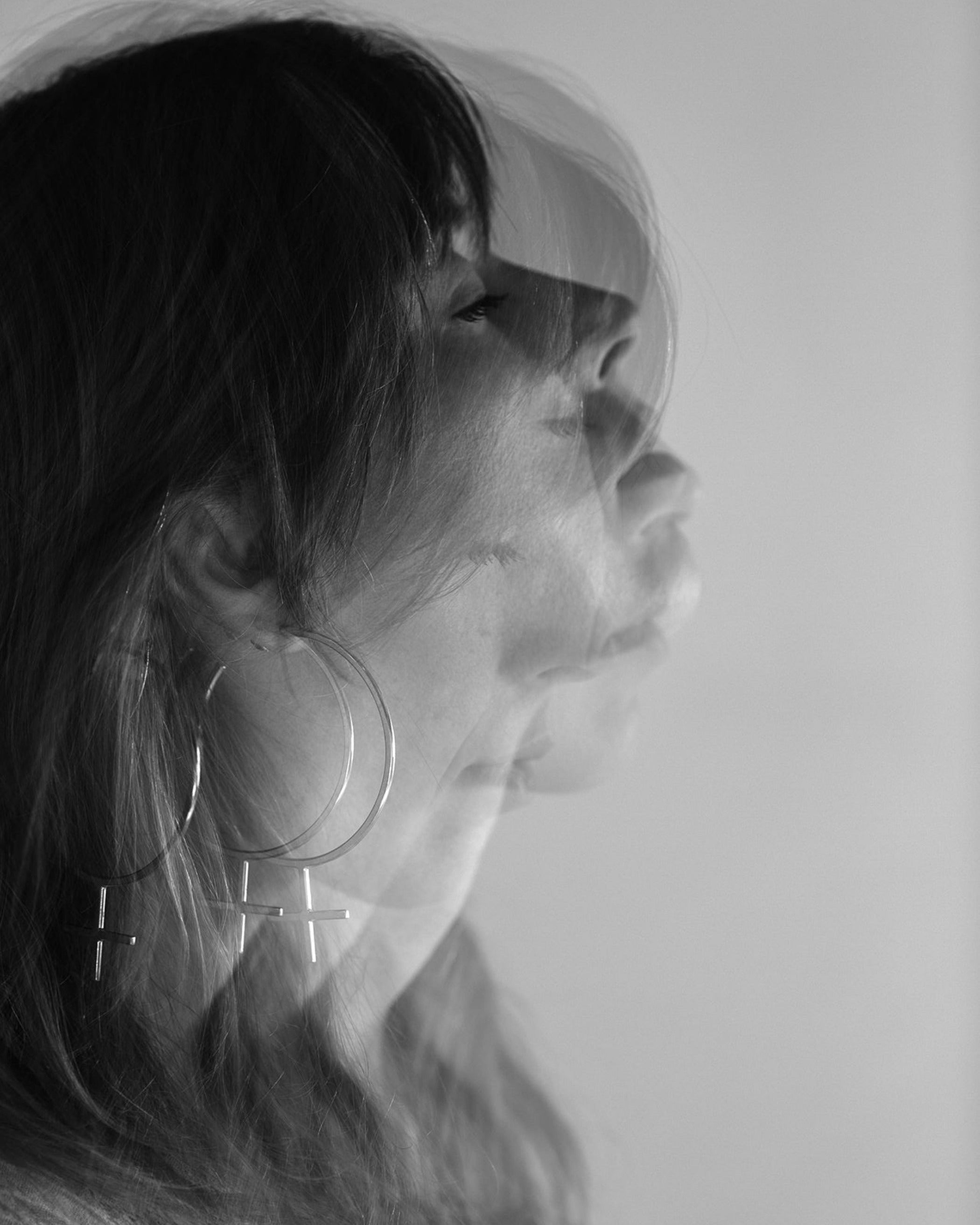 Editorial Photo shoot by Cassie Sullivan Photography of a model in black and white Double Exposure movement image wearing Sterling Silver Venus Symbol Large Oversized Feminist Hoop Earrings 