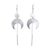 Lunar Thread Earrings on a white background. These sterling silver earrings feature a textured disc and crescent moon hanging from a hook and fine chain fitting.