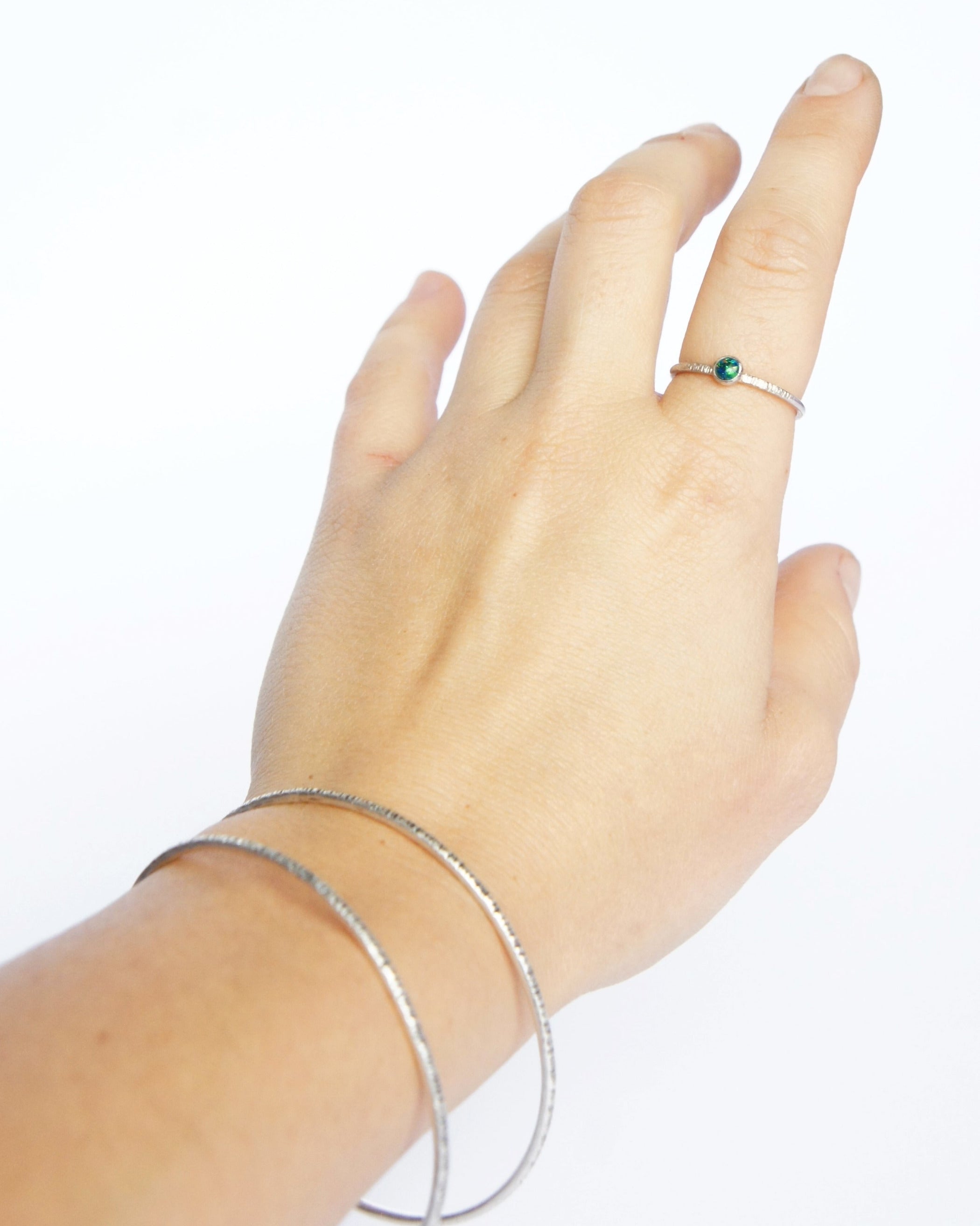 Emily Eliza Arlotte Handcrafted Fine Jewellery - Sterling Silver Opal Dainty Galaxy Ring Worn Hand on white background Bangles Textured