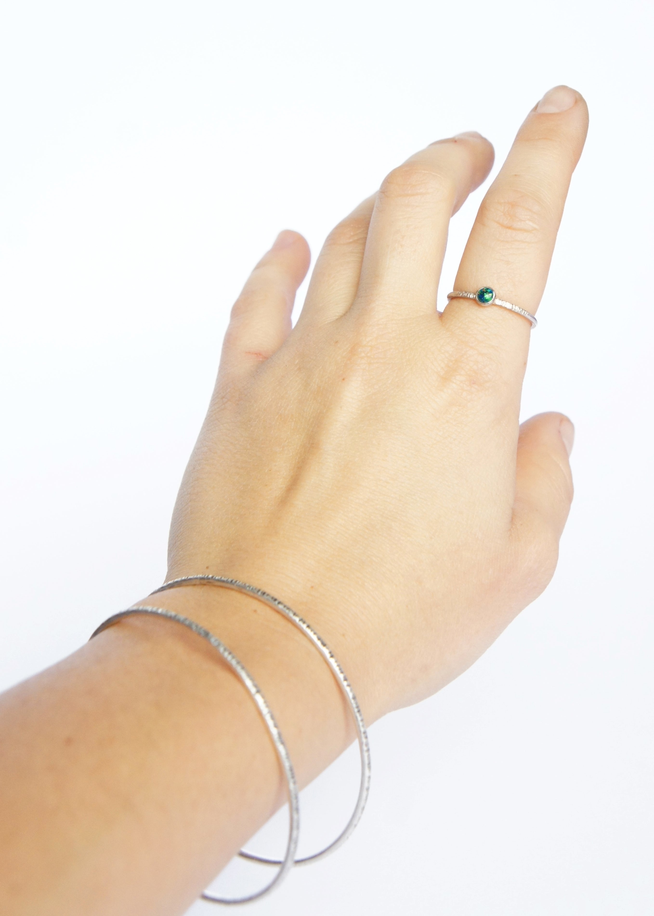 Emily Eliza Arlotte Handcrafted Fine Jewellery - Sterling Silver Opal Dainty Galaxy Ring Worn Hand on white background Bangles Textured