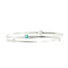 Two Sterling Silver Opal Bangles that have a textured finish sit on a white background.