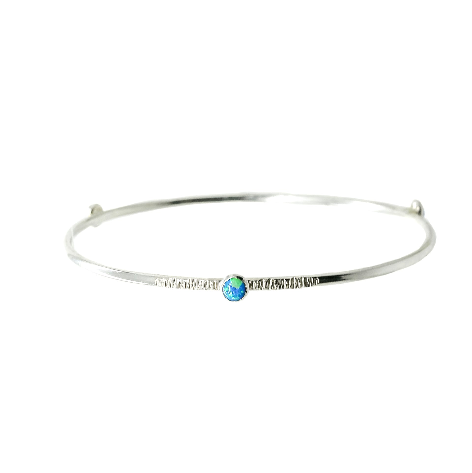 A Sterling Silver Blue Opal Bangle with a textured finish sits on a white background.