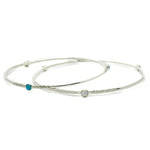 Two Sterling Silver Opal Bangles that have a textured finish sit on a white background.