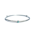 A Sterling Silver Opal Bangle with a textured finish sits on a white background.